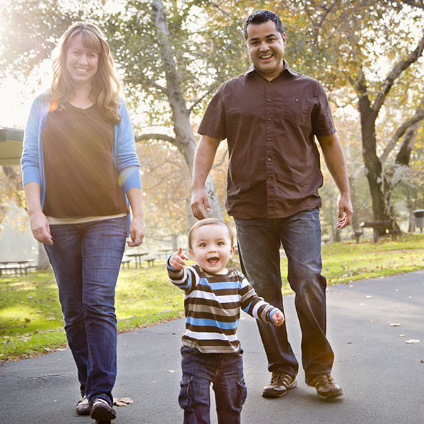 Toddler walking with parents outside